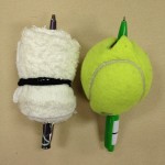 Rolled up wash cloth and tennis ball, each with a pen stuck through them