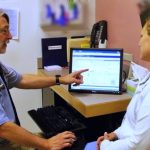 Doctor showing computer screen to patient
