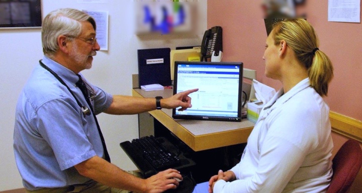 Doctor showing computer screen to patient